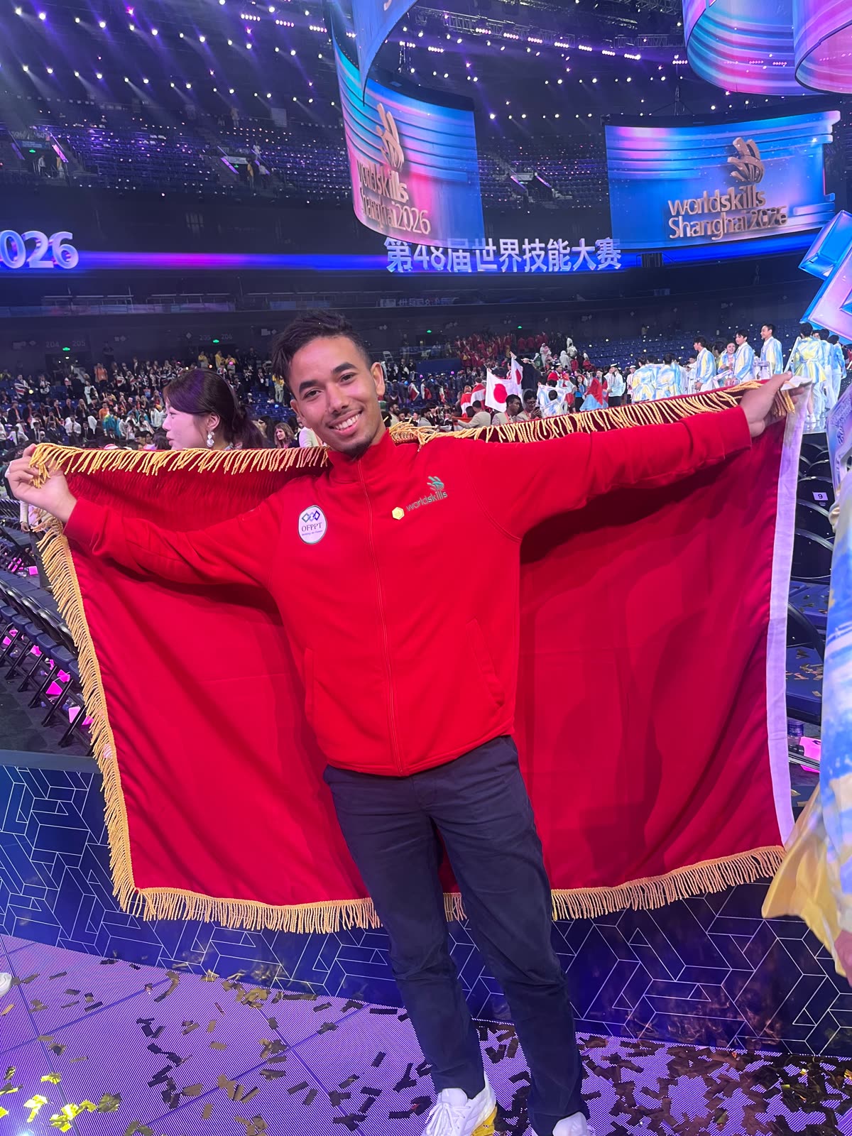 Youssef Rhannam déployant le drapeau marocain dans l'arène WorldSkills
